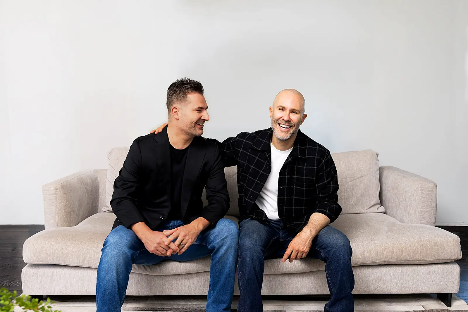 Dr Jake Sloane and David Segal, co-founders of Inside Aesthetics, laughing together on a sofa